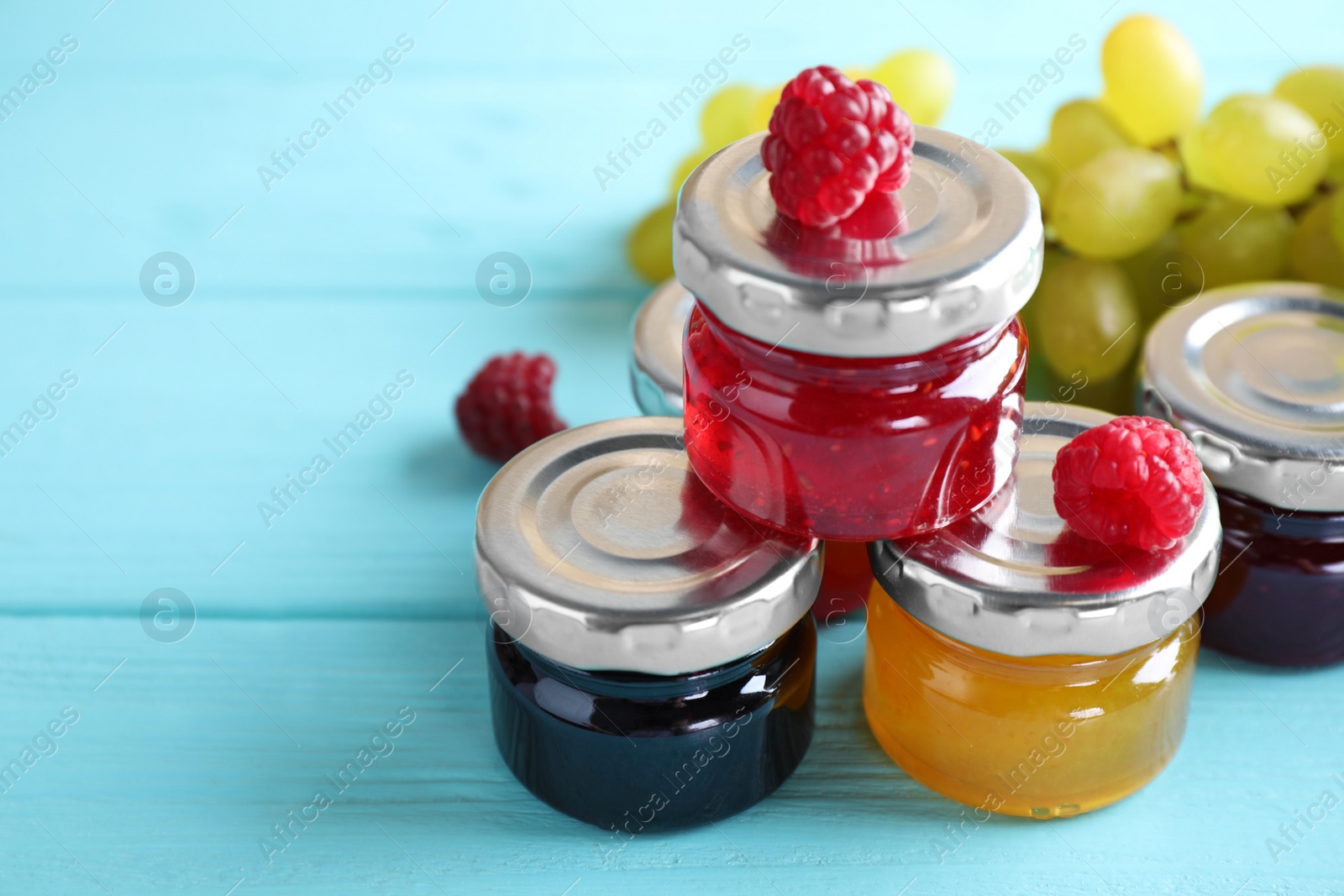 Image of Different jams in glass jars on turquoise table