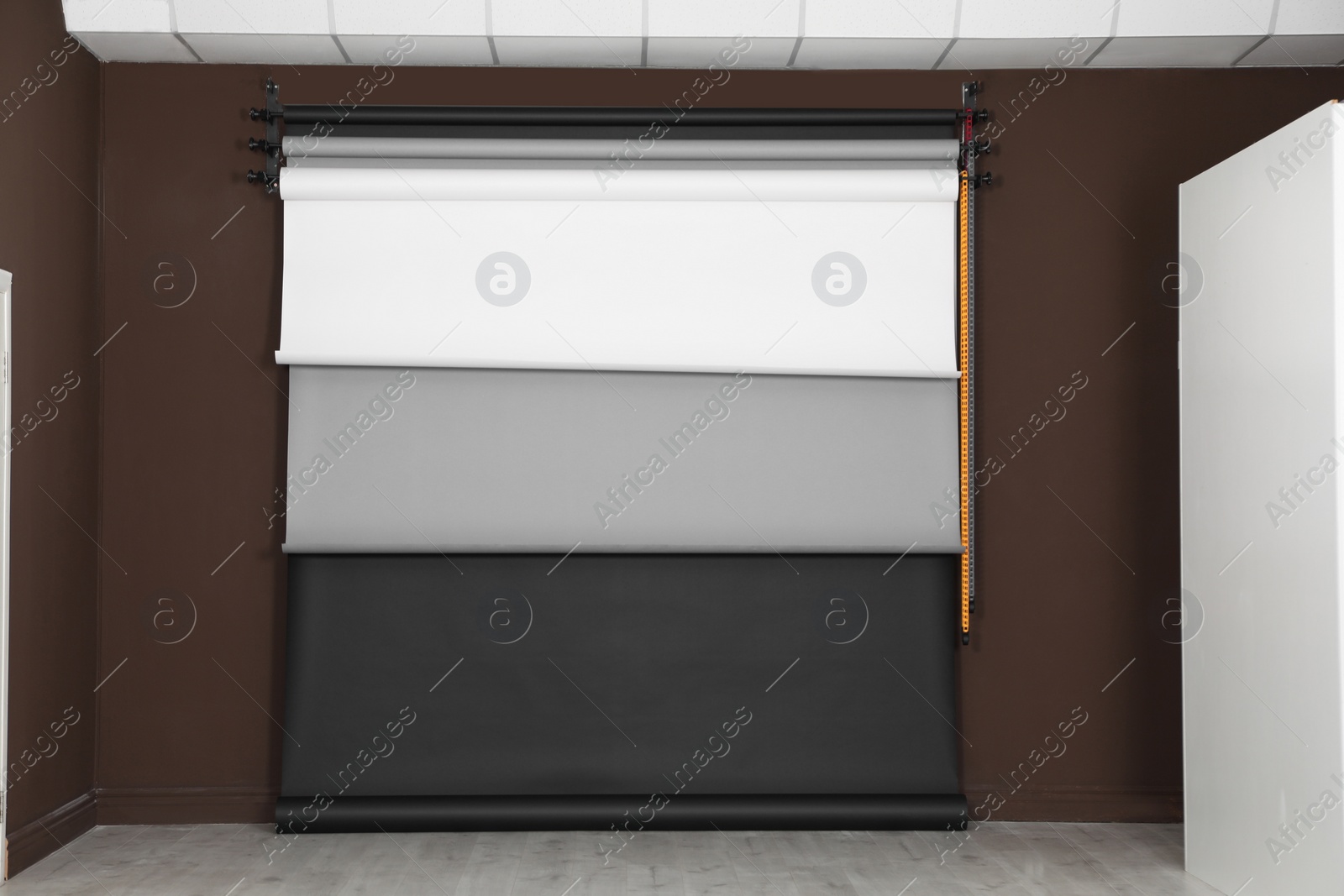 Photo of Colorful photo background rolls on brown wall in studio