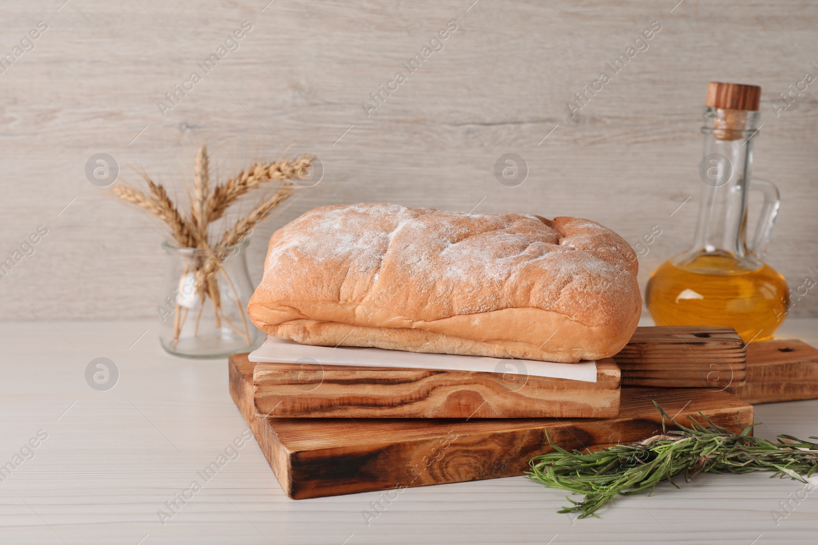 Photo of Composition with fresh crispy ciabatta on white wooden table