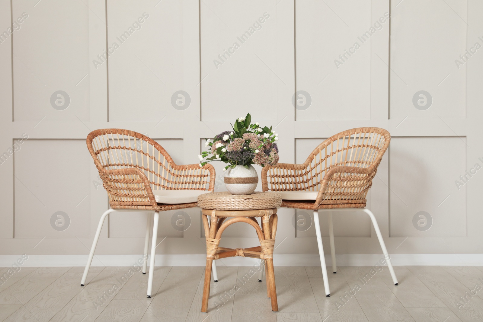 Photo of Simple room interior with set of wicker furniture and beautiful flowers