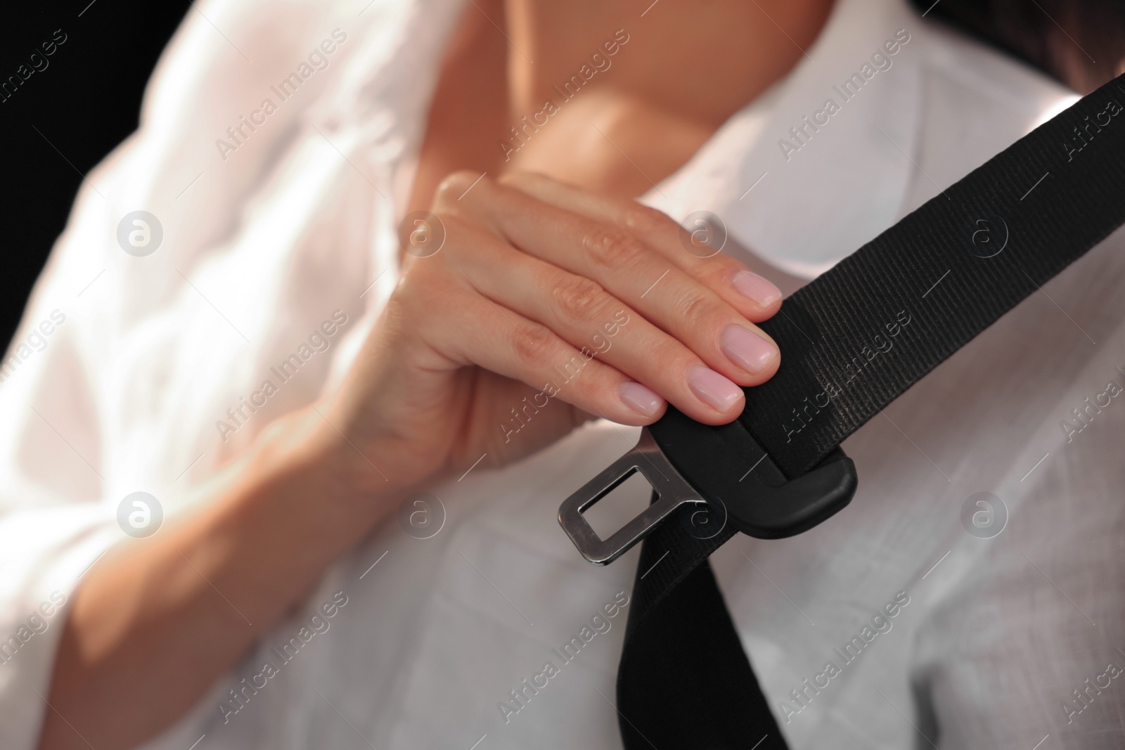 Photo of Woman pulling seat belt in car, closeup