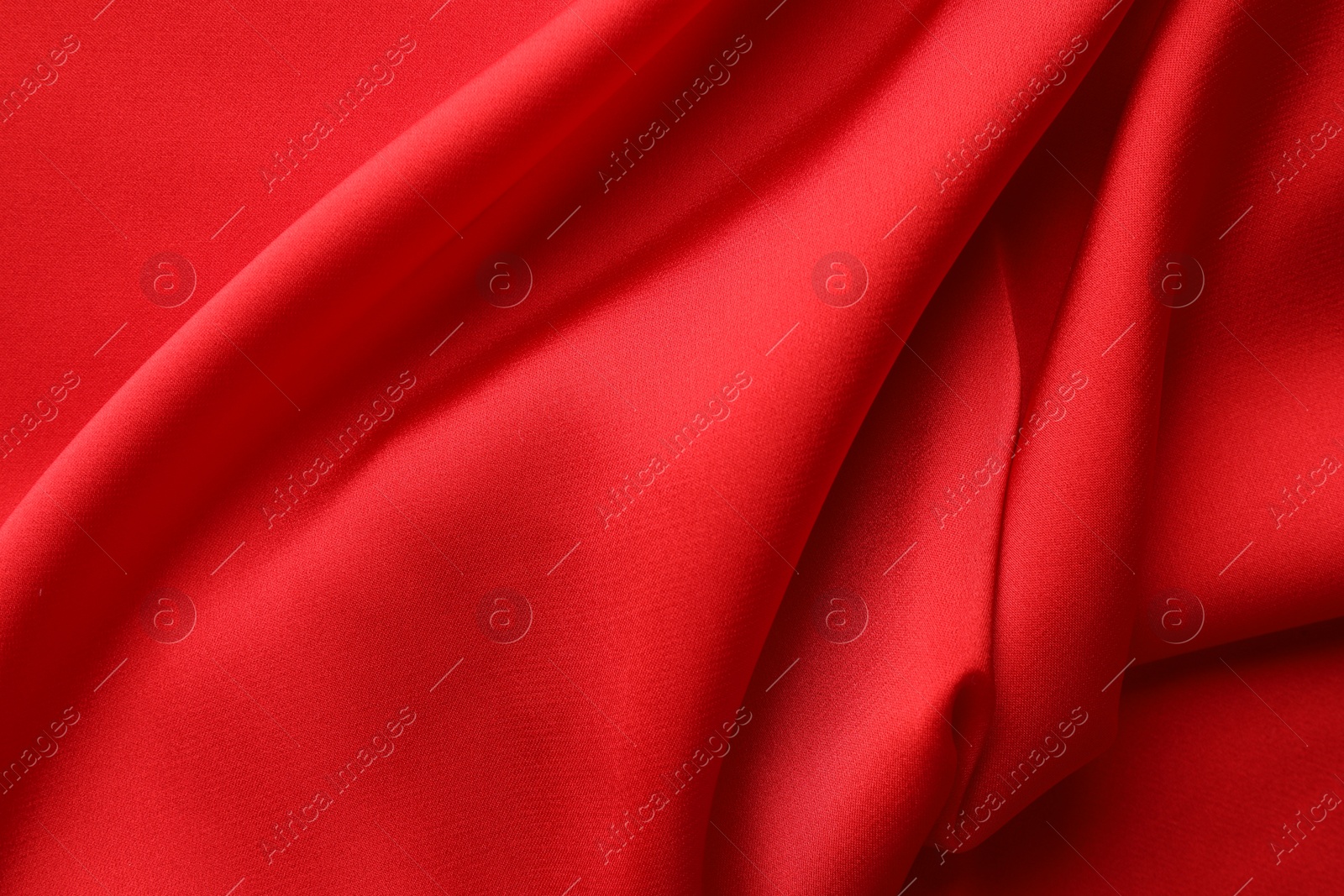 Photo of Crumpled red silk fabric as background, top view