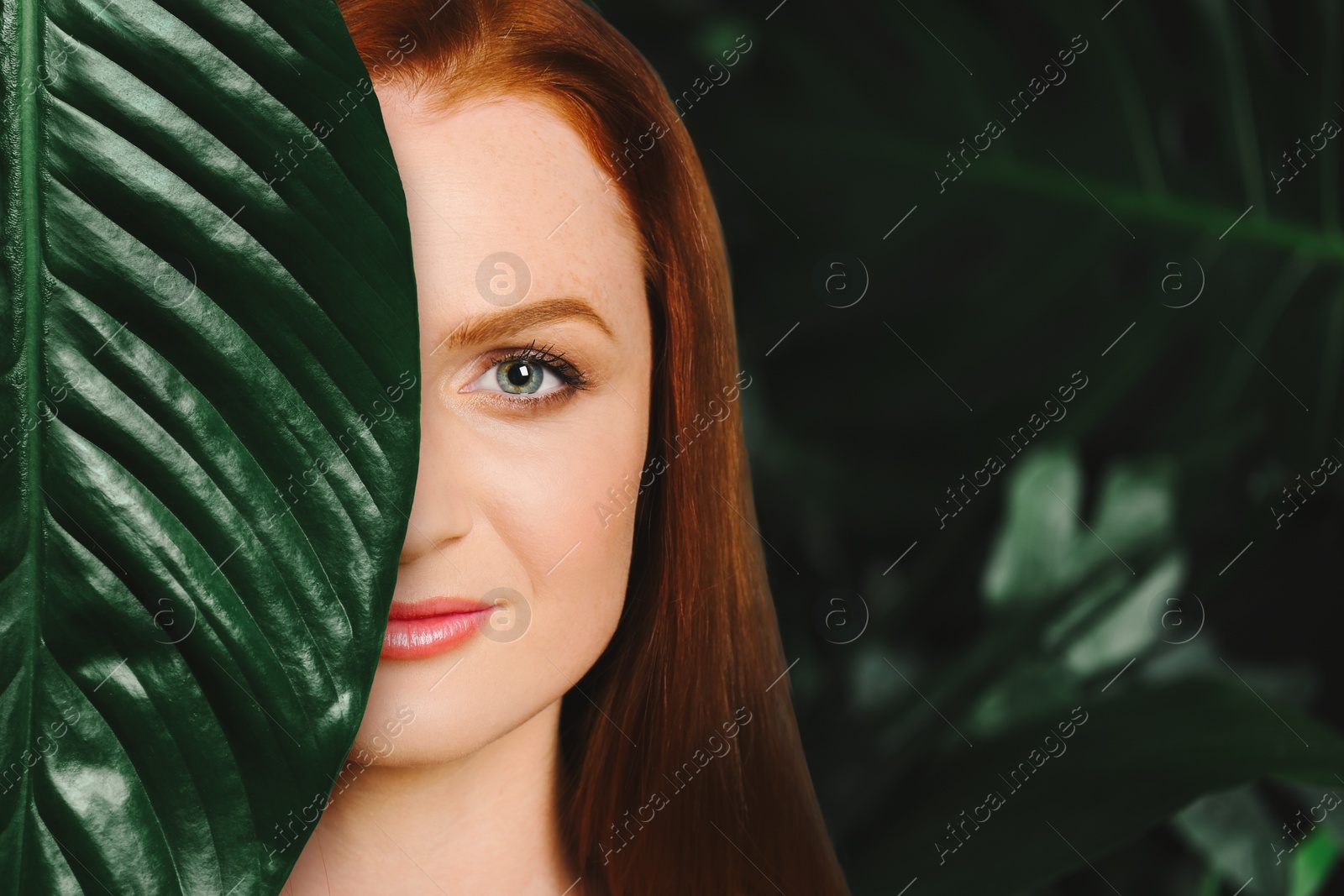 Image of Beautiful young woman surrounded by green leaves feeling harmony while enjoying nature