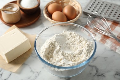 Making shortcrust pastry. Different ingredients for dough and whisk on white marble table