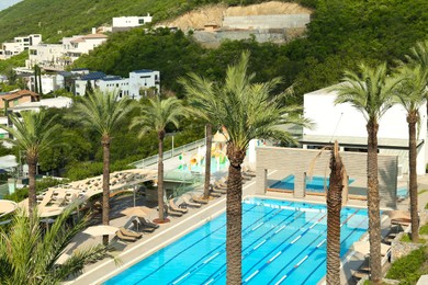 Outdoor swimming pool and tropical plants at luxury resort on sunny day