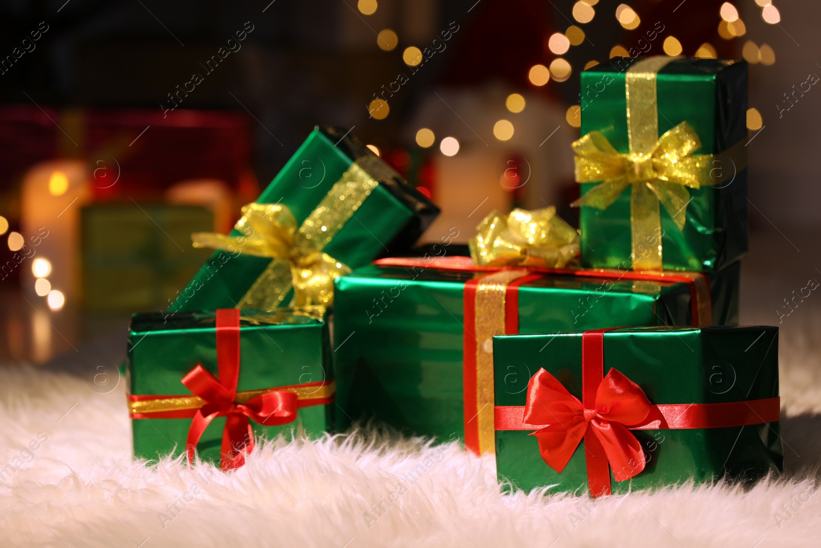 Photo of Beautiful Christmas gifts on furry carpet in room