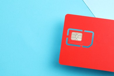 Photo of Red SIM card on color background, top view. Space for text