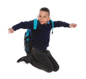 Photo of Full length portrait of cute African-American boy in school uniform jumping on white background