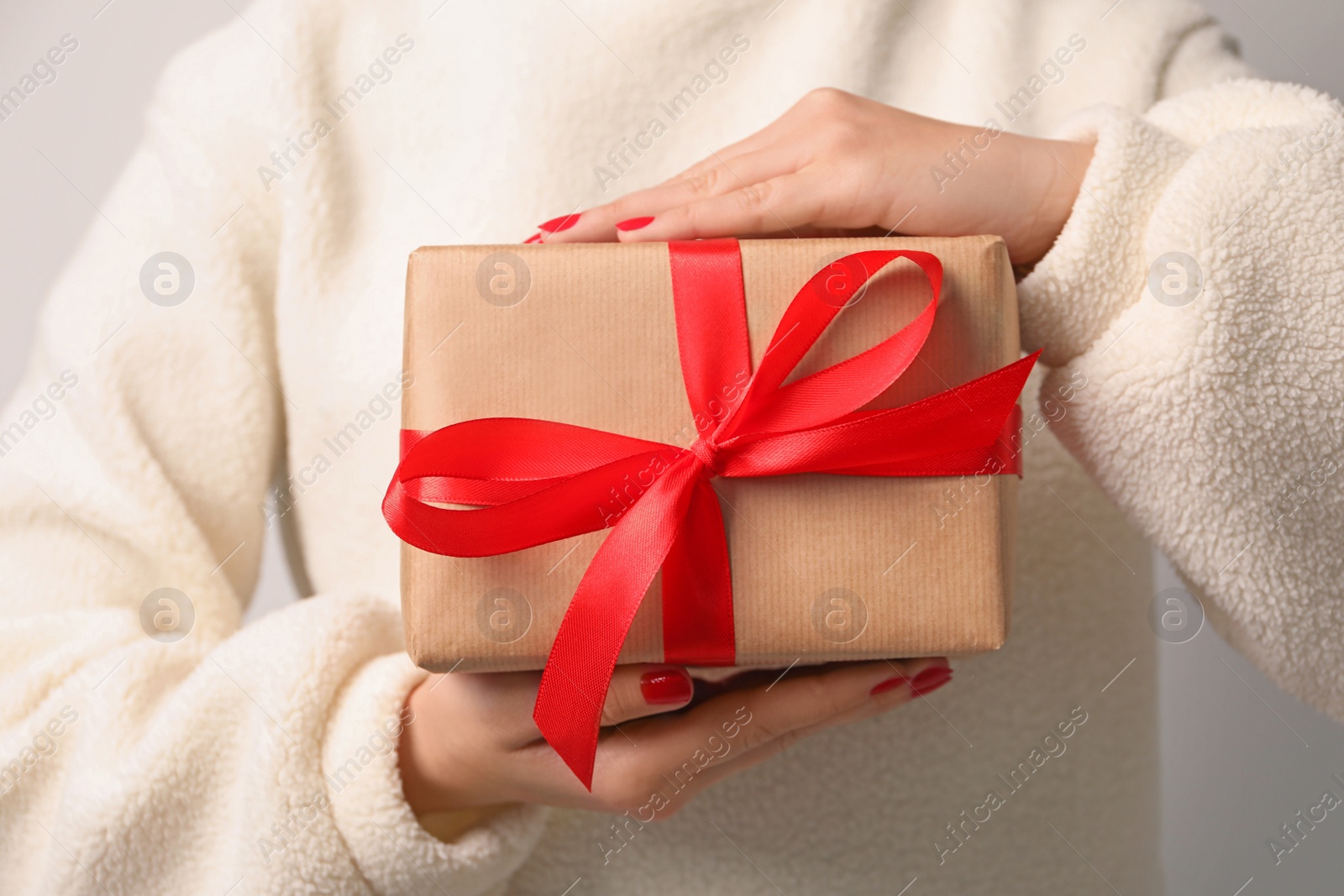 Photo of Christmas present. Woman holding gift box, closeup