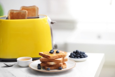 Photo of Toaster and sandwiches on white marble table in kitchen. Space for text