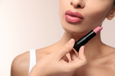 Woman with pink lipstick on light background, closeup