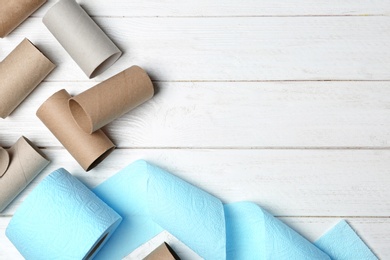 Flat lay composition with toilet paper and empty rolls on wooden background. Space for text