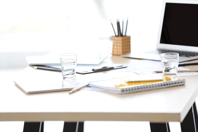 Photo of Workplace with laptop and office supplies indoors