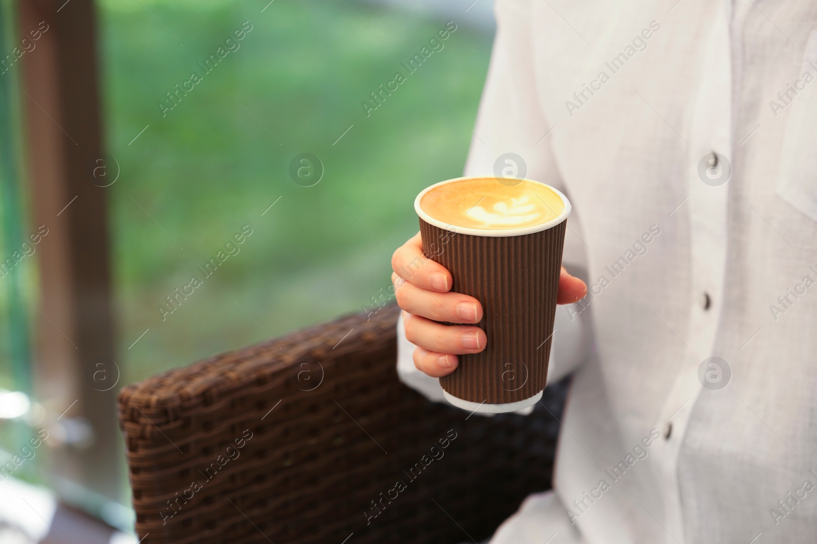 Photo of Woman holding takeaway paper cup outdoors, closeup and space for text. Coffee to go