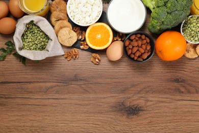 Photo of Set of natural food high in calcium on wooden table, flat lay. Space for text