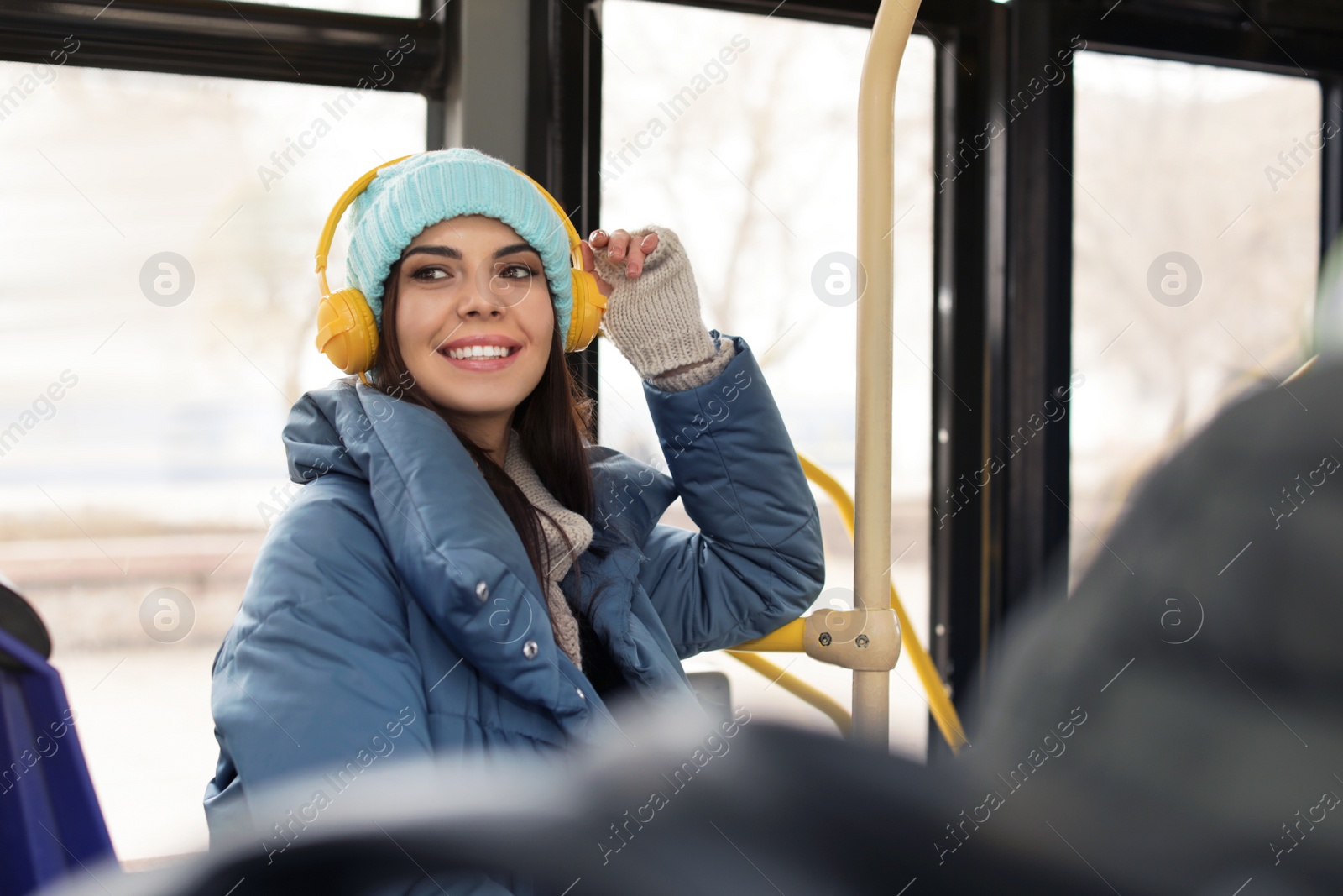 Photo of Young woman listening to music with headphones in public transport