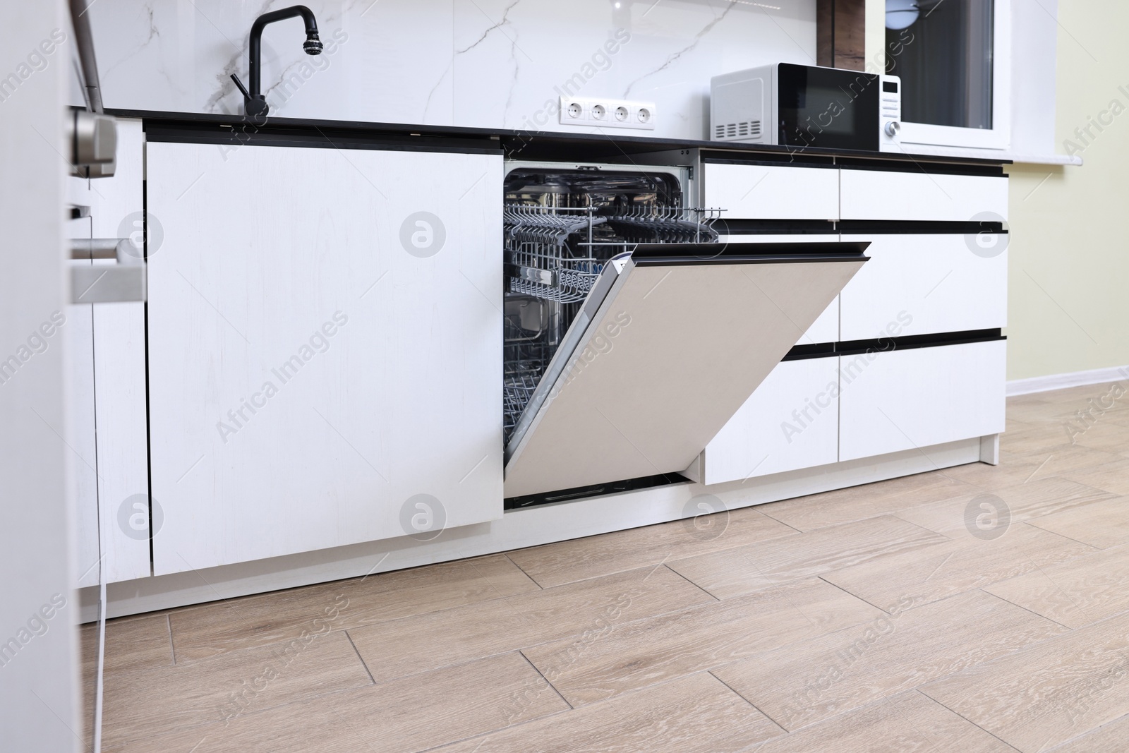 Photo of Built-in dishwasher with open door in kitchen