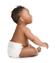 Adorable African-American baby in diaper on white background