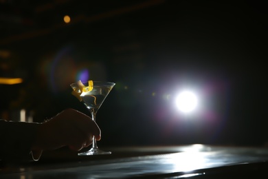 Photo of Barman with glass of lemon drop martini cocktail in pub, closeup. Space for text