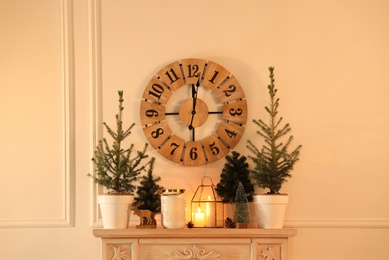 Photo of Small fir trees on mantelpiece indoors. Christmas interior design