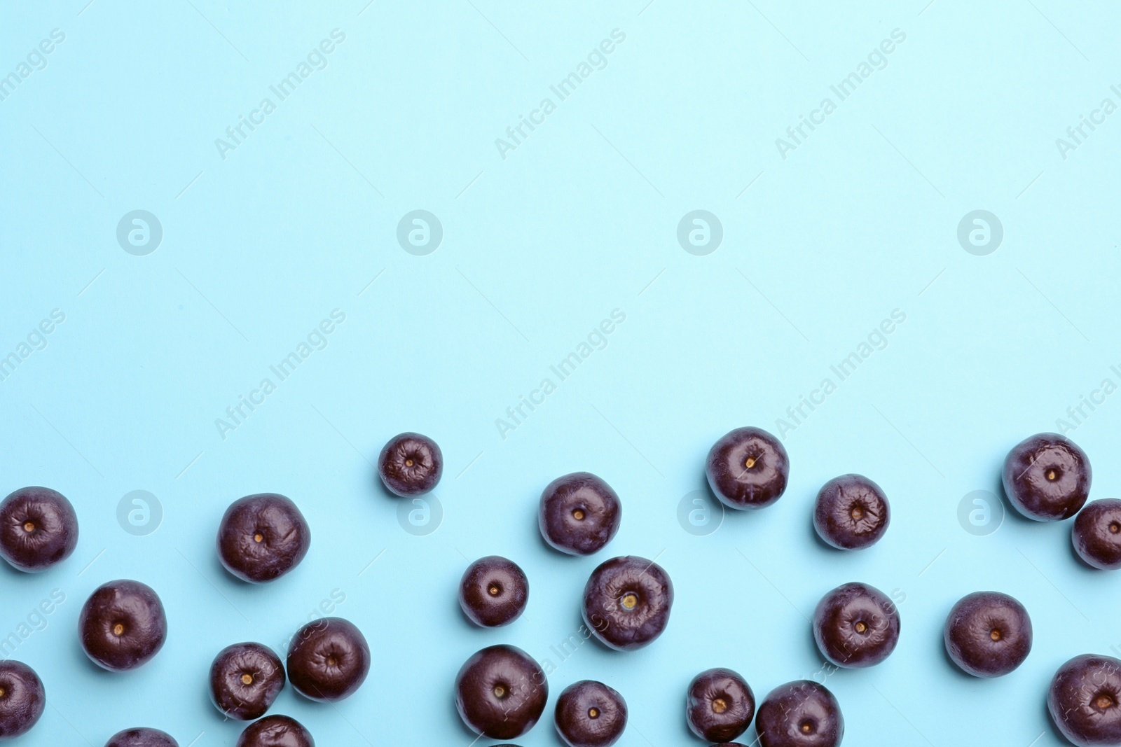 Photo of Fresh acai berries on blue background, flat lay. Space for text