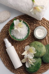 Flat lay composition with different spa products and beautiful flowers on white table