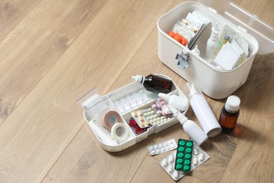 Photo of First aid kit and medicaments on floor indoors, space for text