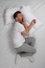 Photo of Man suffering from insomnia in bed, top view