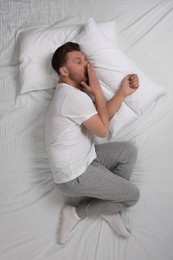 Man suffering from insomnia in bed, top view