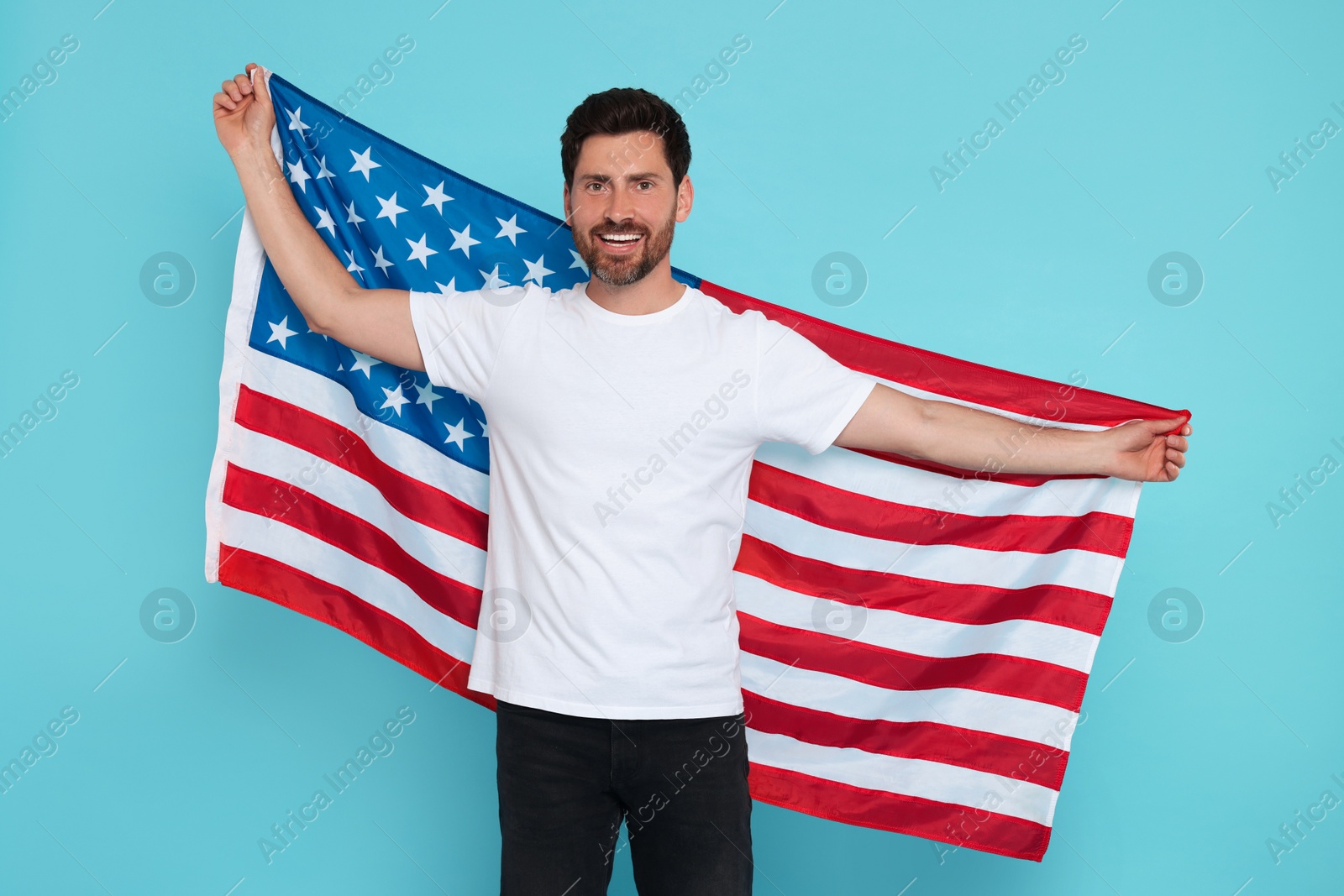 Photo of 4th of July - Independence Day of USA. Happy man with American flag on light blue background