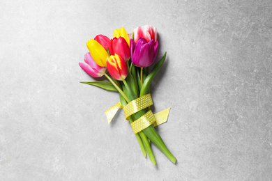 Beautiful spring tulips on light grey stone table, top view