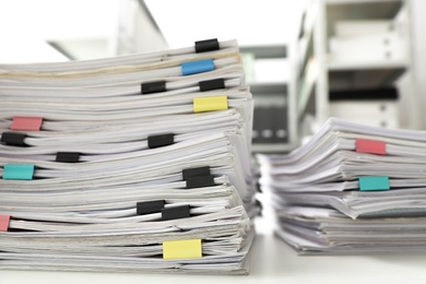 Photo of Stacks of documents with paper clips on office desk, closeup