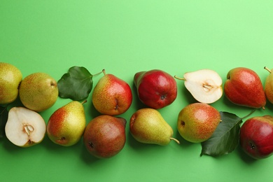 Ripe juicy pears on green background, flat lay