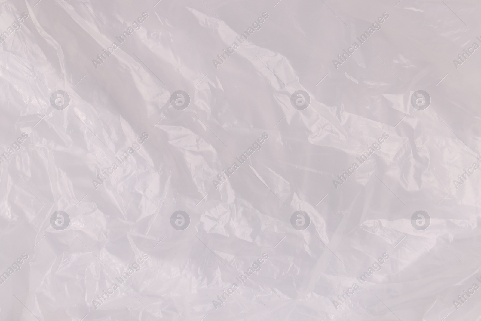 Photo of Crumpled transparent plastic bag as background, top view