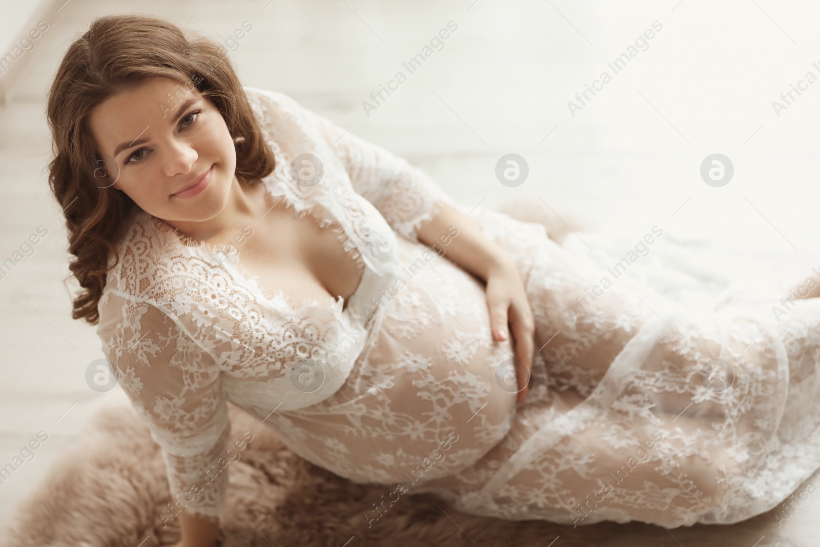 Photo of Young pregnant woman in elegant dress at home