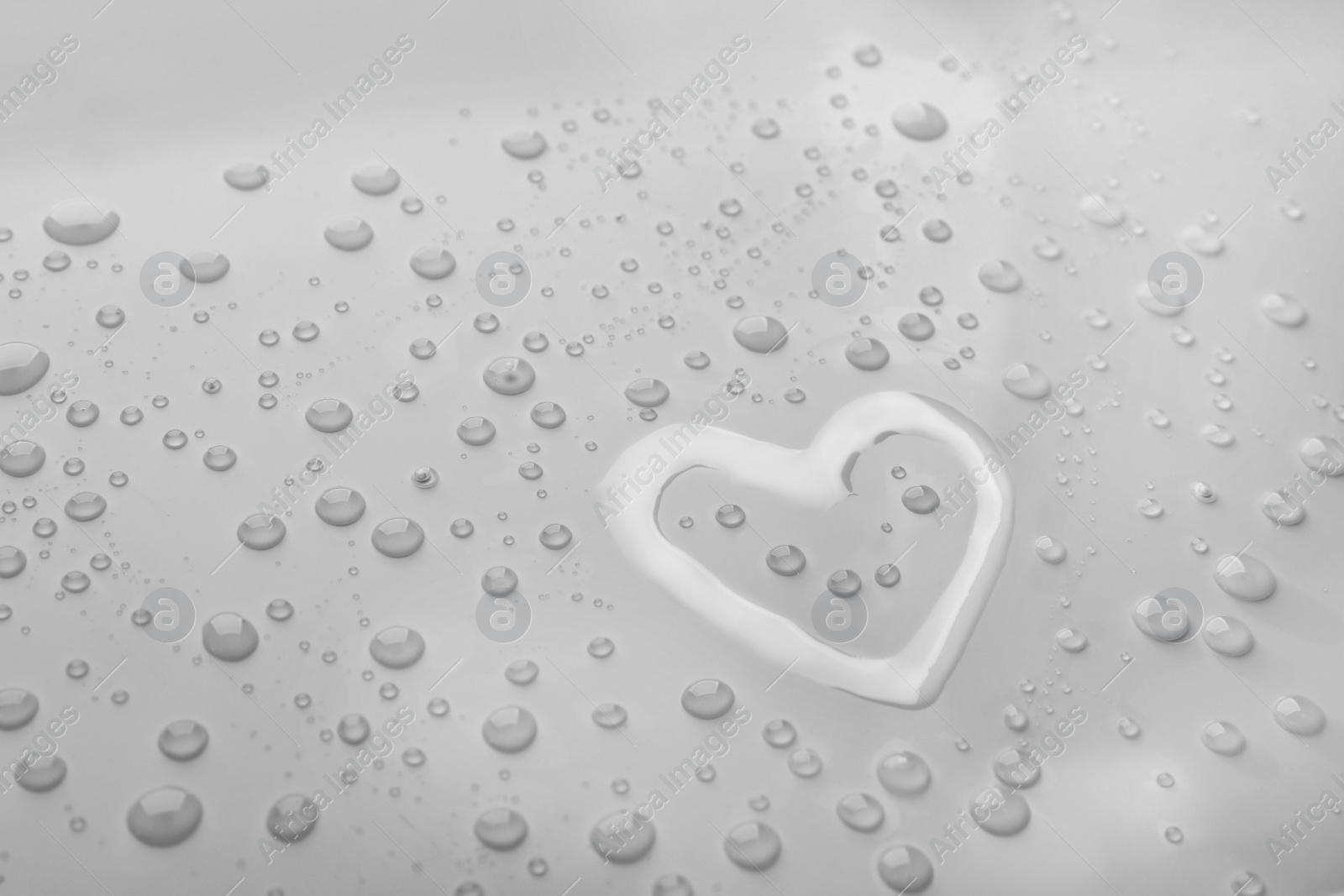 Photo of Heart shape of water and drops on light background