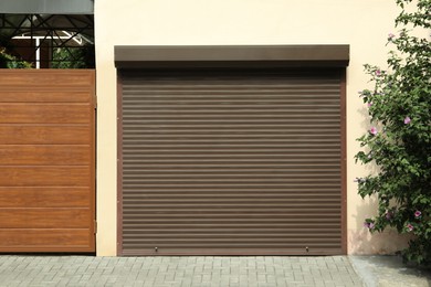 Photo of Building with brown roller shutter garage door on sunny day