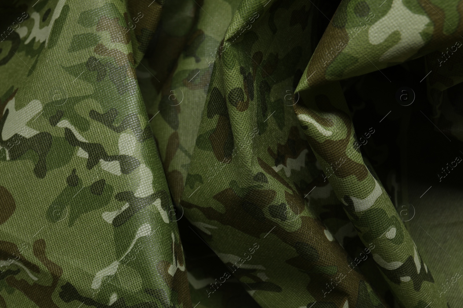 Photo of Texture of crumpled camouflage fabric as background, top view