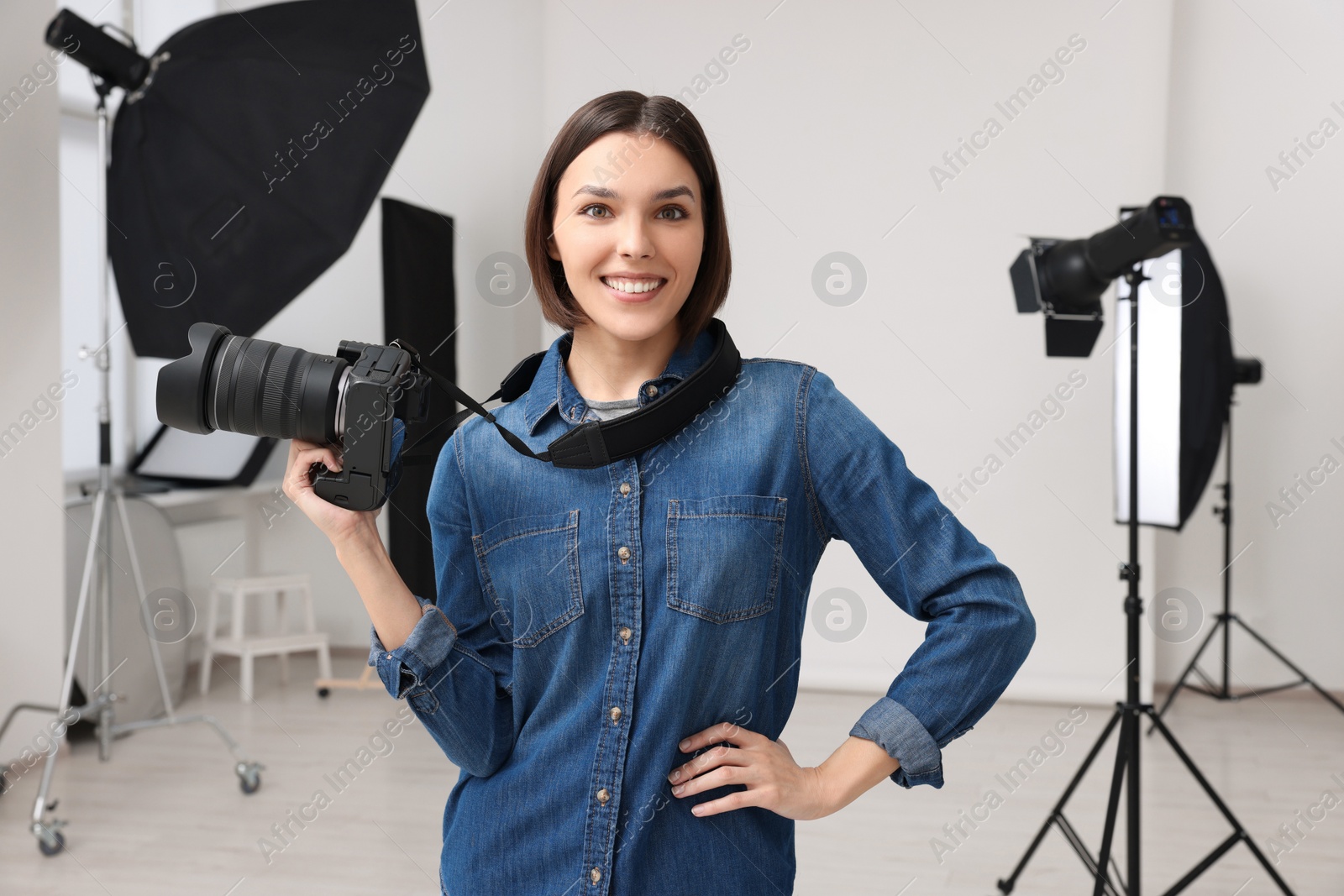 Photo of Professional photographer with camera in modern photo studio