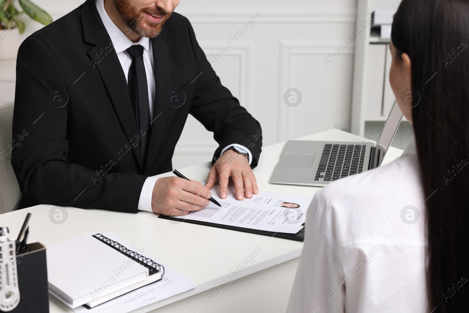 Photo of Human resources manager reading applicant's resume in office, closeup