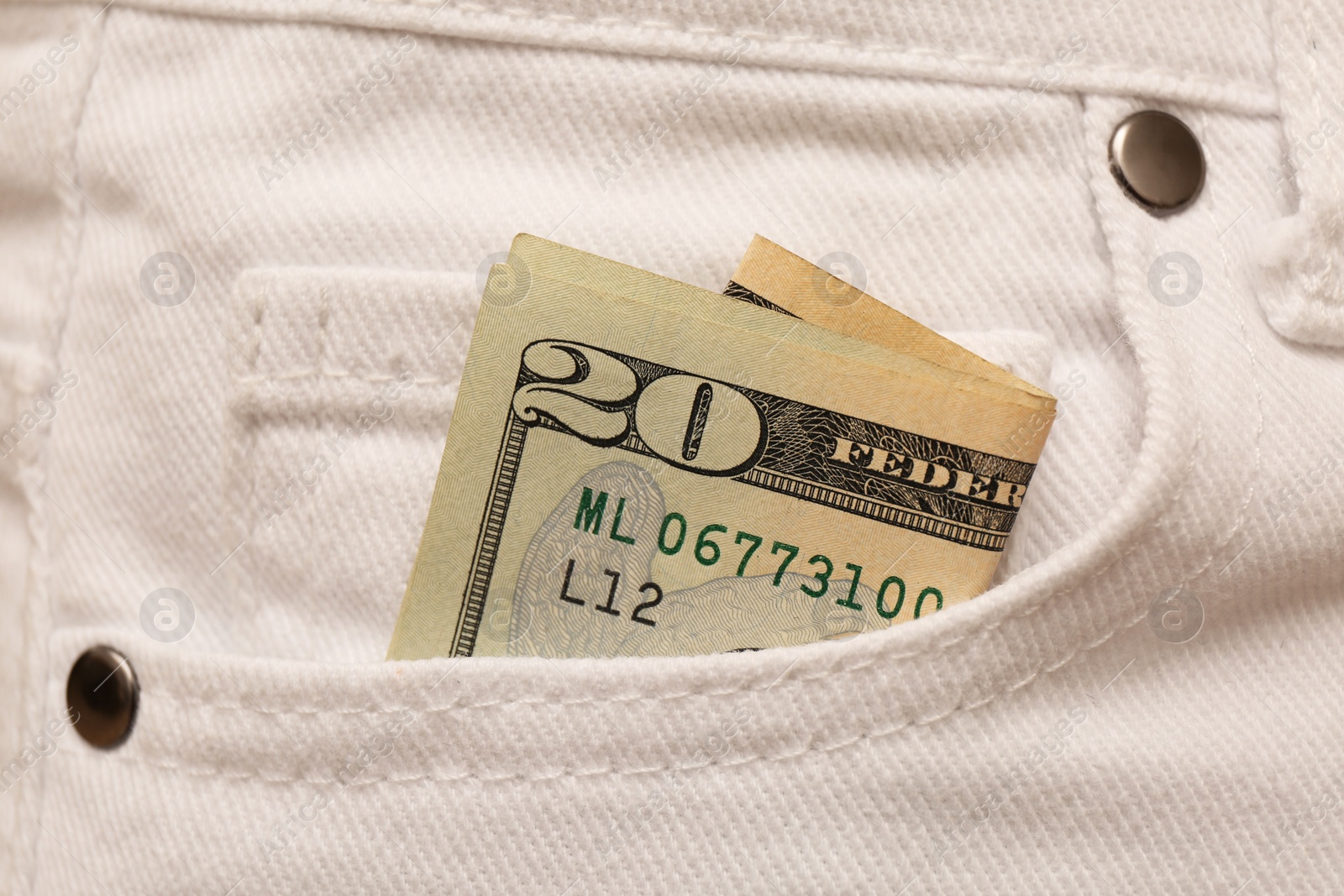 Photo of Dollar banknote in pocket of white jeans, closeup. Spending money