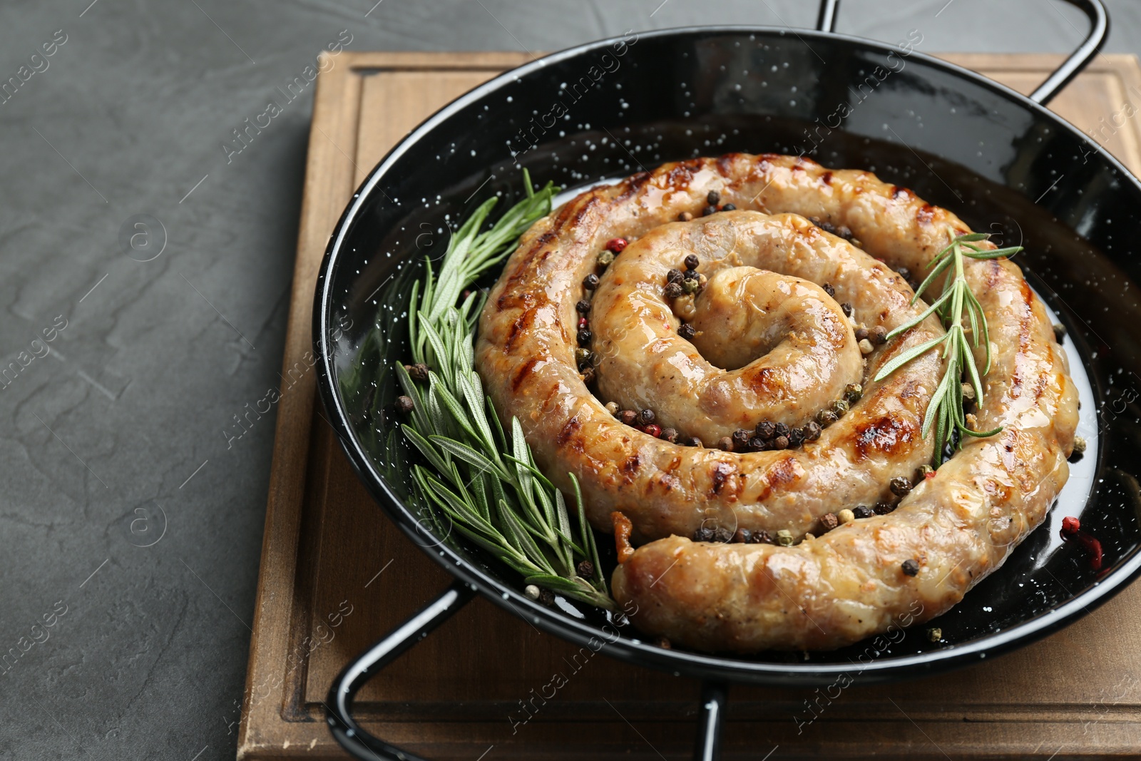 Photo of Tasty homemade sausages with spices on grey table