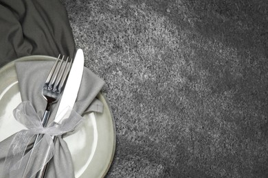 Photo of Stylish setting with elegant cutlery on grey table, top view. Space for text