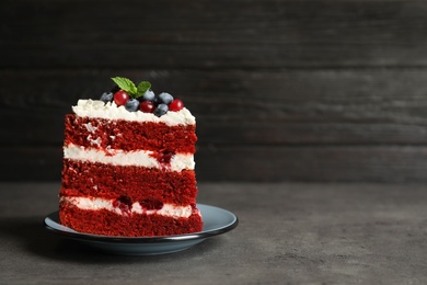 Photo of Plate with piece of delicious homemade red velvet cake and space for text on blurred background