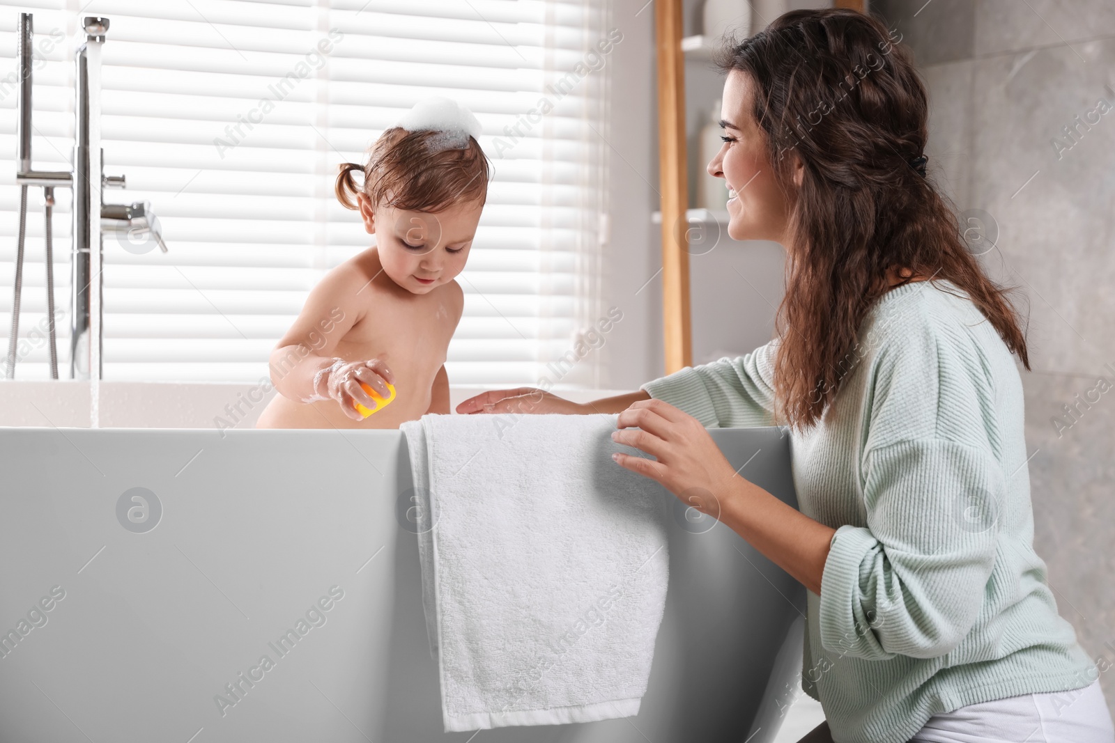 Photo of Mother with her little daughter in bathroom