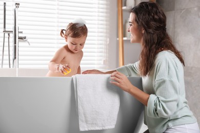 Mother with her little daughter in bathroom