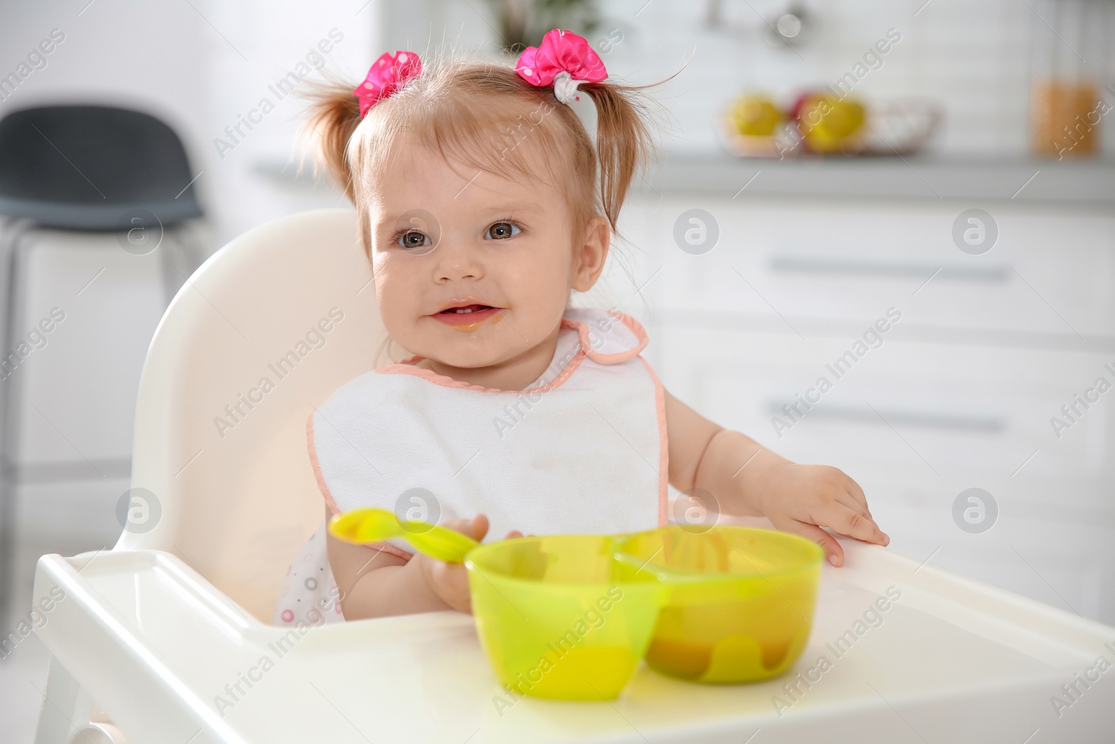 Photo of Cute little girl eating healthy food in kitchen