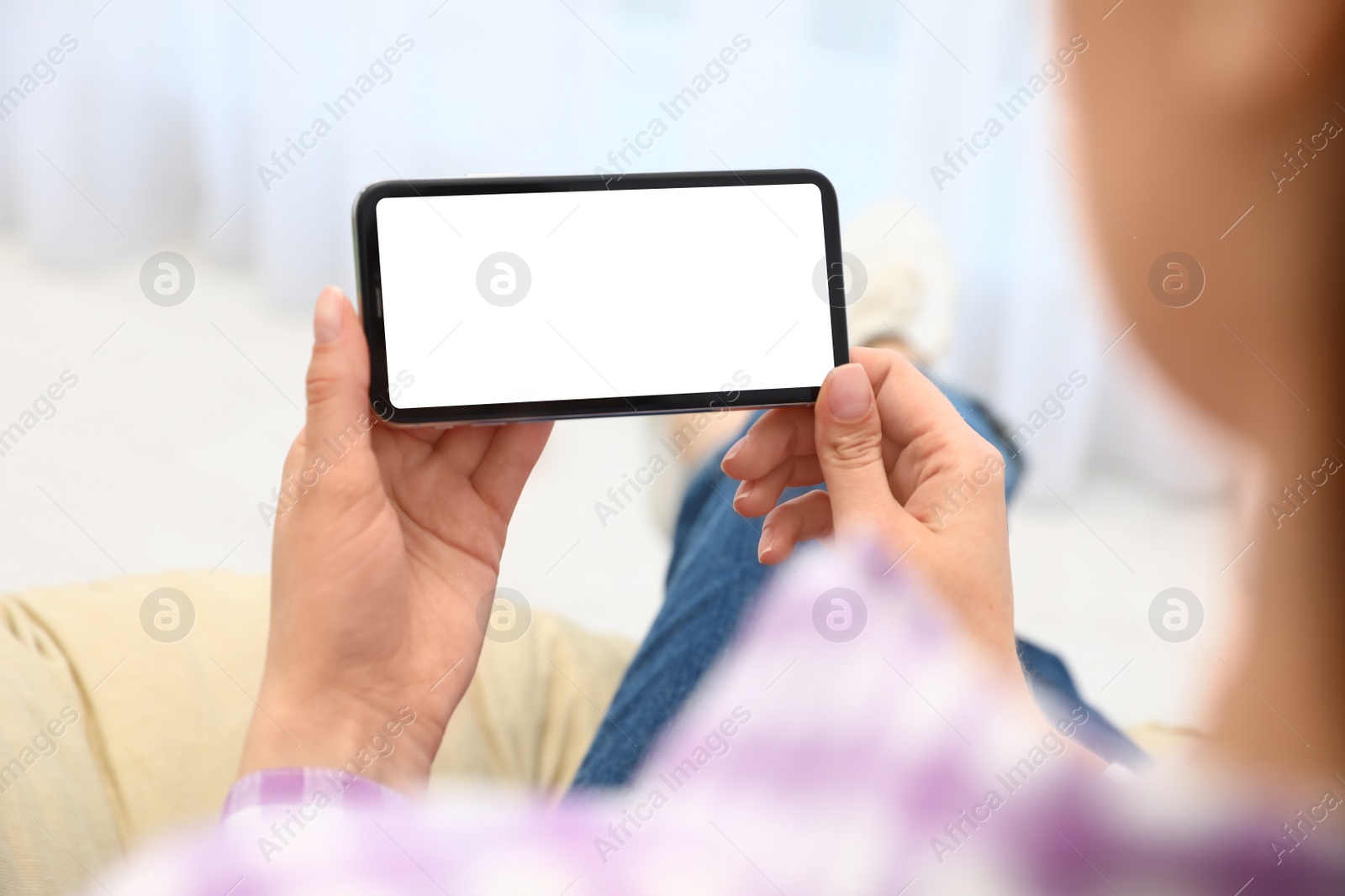 Photo of Woman holding smartphone with blank screen indoors, closeup of hands. Space for text