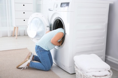 Adorable little girl having fun at home on laundry day