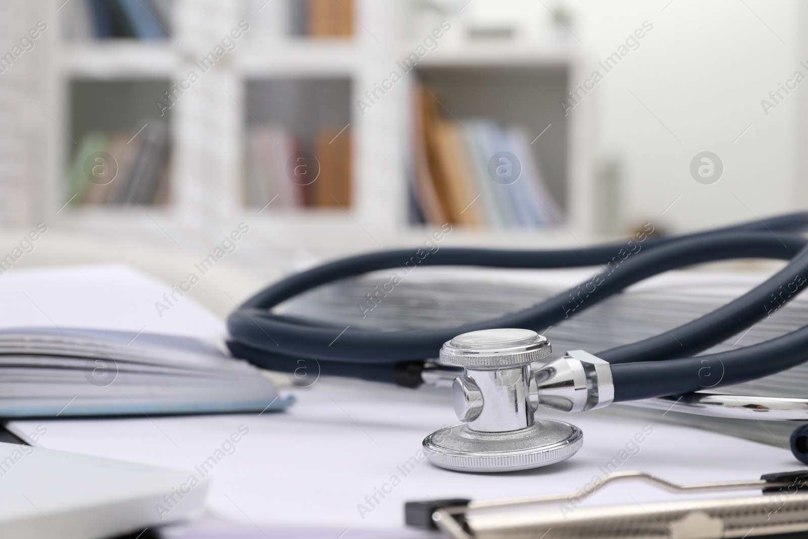 Photo of Book, stethoscope and clipboard indoors, closeup with space for text. Medical education